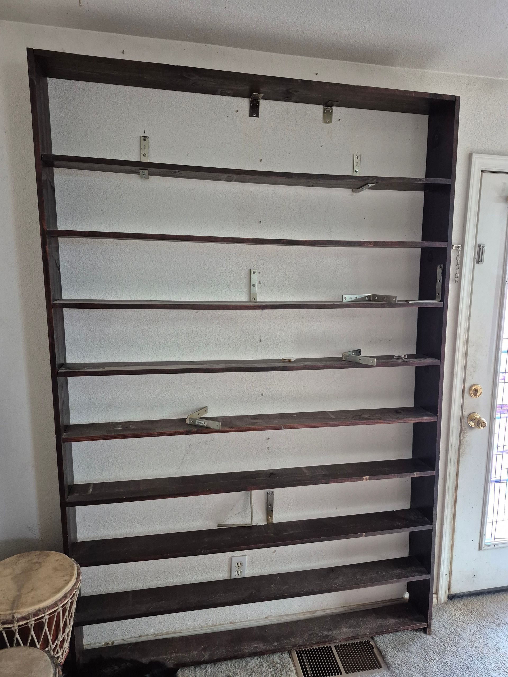Dark wooden shelving unit mounted on a white wall.