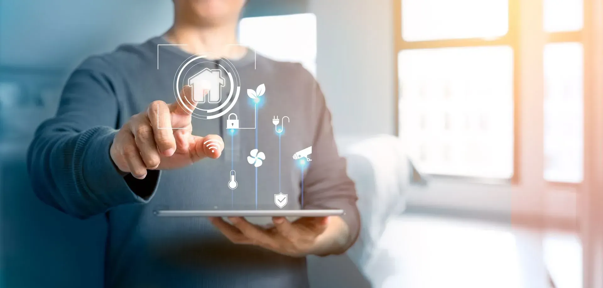 Person using a tablet to control a smart home system with digital icons.