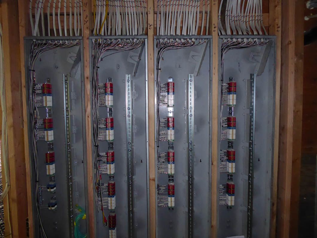 A bunch of electrical panels are hanging on a wall.