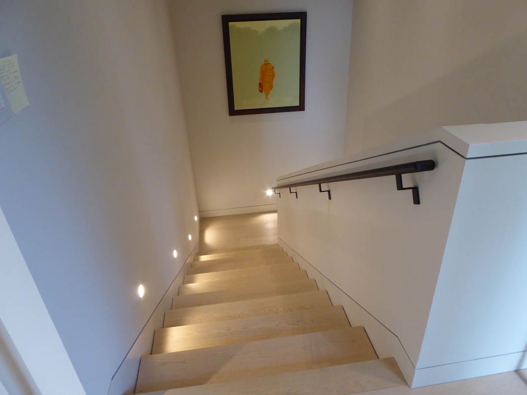 A staircase with a picture on the wall above it