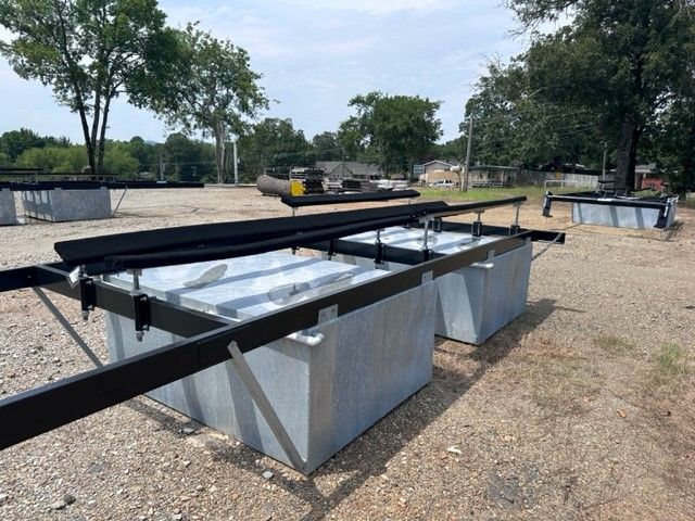 A bunch of containers are sitting on top of a dirt field.