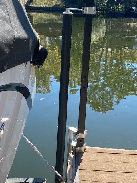 A boat is docked at a dock next to a body of water.