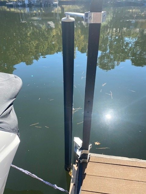 A boat is docked at a dock next to a body of water