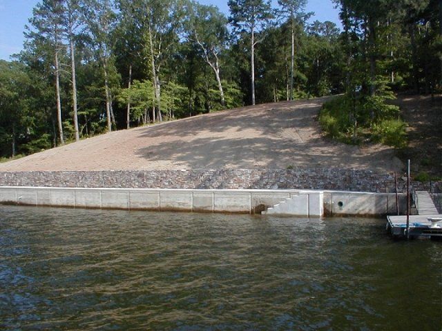 A large body of water surrounded by trees and a dock