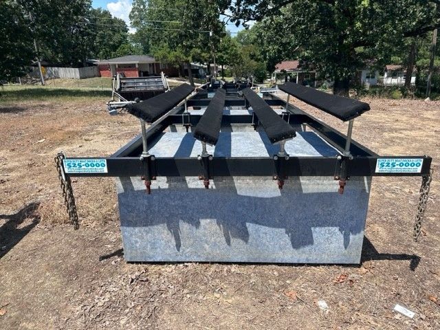 A large metal container with black seats is sitting in a dirt field.