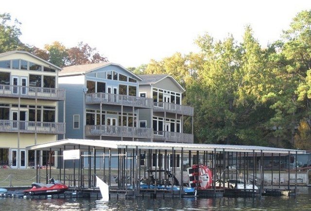 A large house sits on the shore of a lake