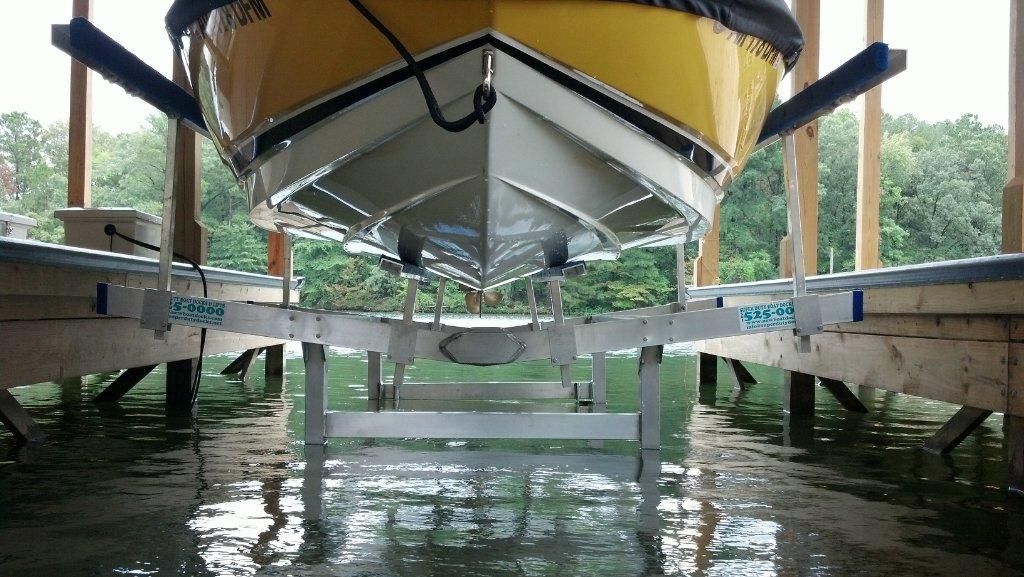 A boat is sitting on a lift in the water