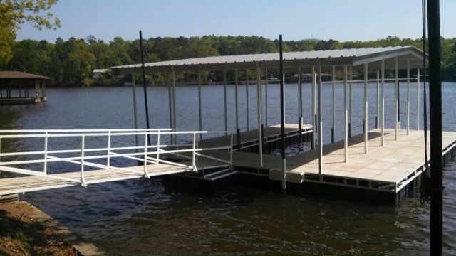 A dock on a lake with a white railing