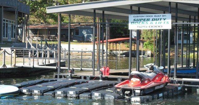 A jet ski is docked at a dock with a sign that says super duty dock & jets