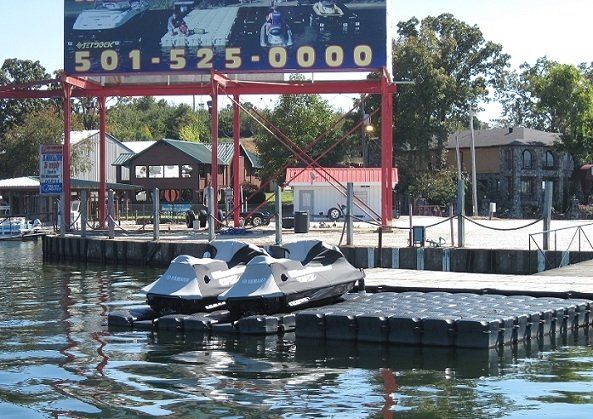 Two jet skis are sitting on a dock under a sign that says 501-525-0000