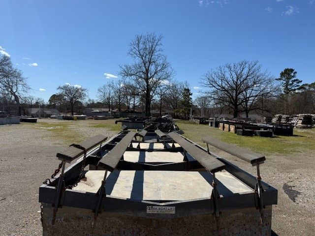 A trailer is parked in a grassy field with trees in the background