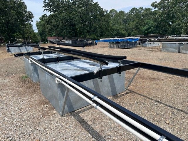 A row of metal boxes sitting on top of a gravel field
