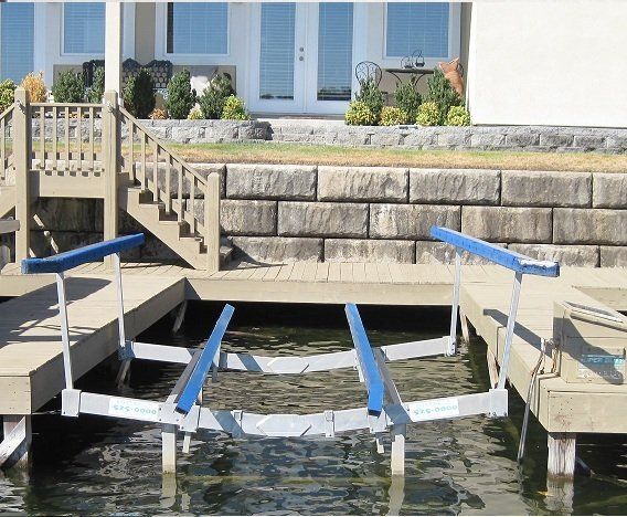 A boat lift is in the water near a house