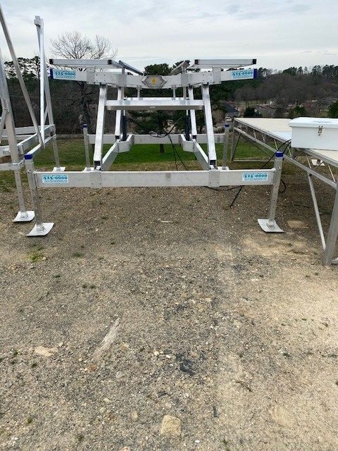 A boat lift is sitting on top of a dirt field.