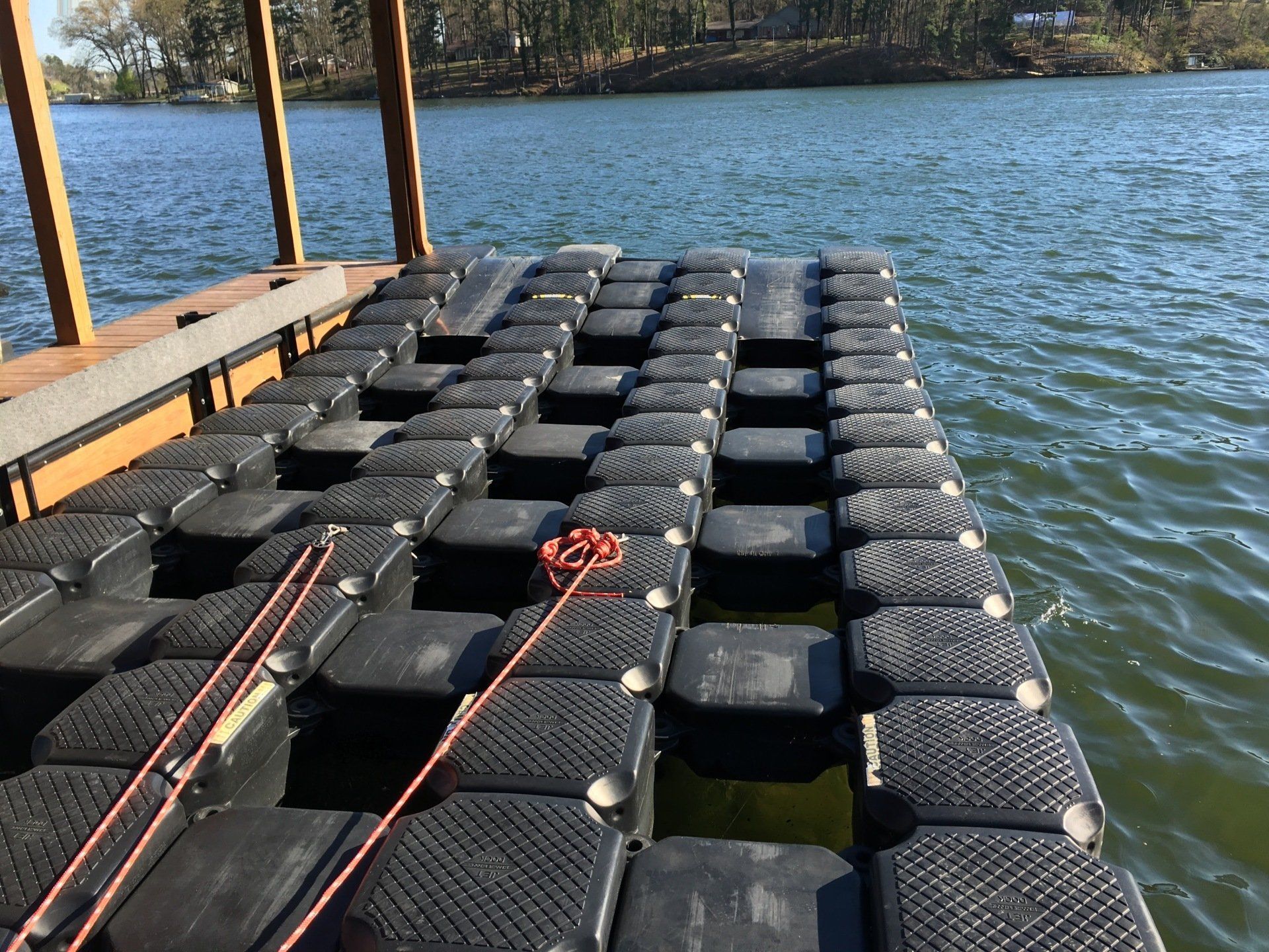 A dock with a lot of black blocks in the water