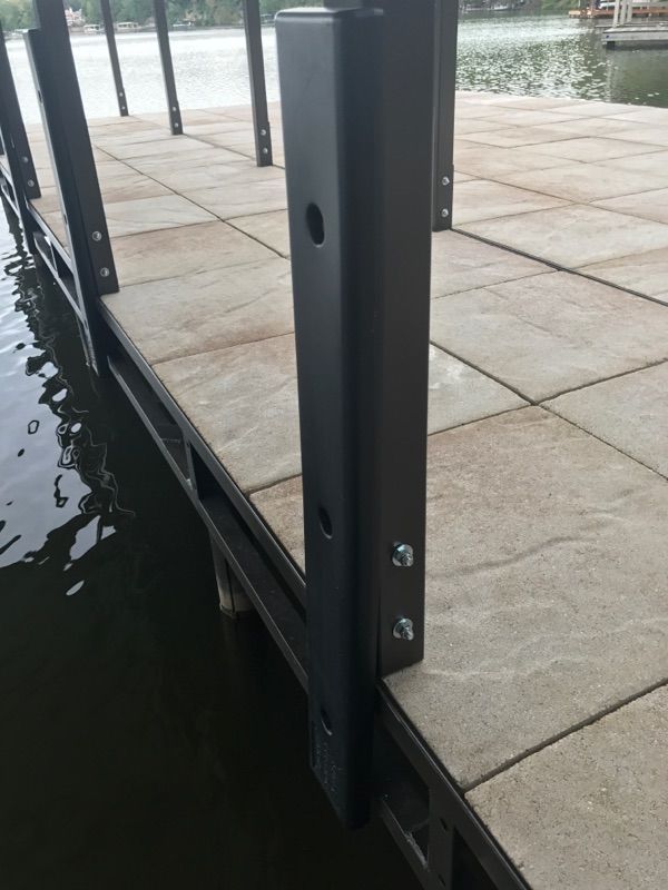 A close up of a dock with a metal post in the water