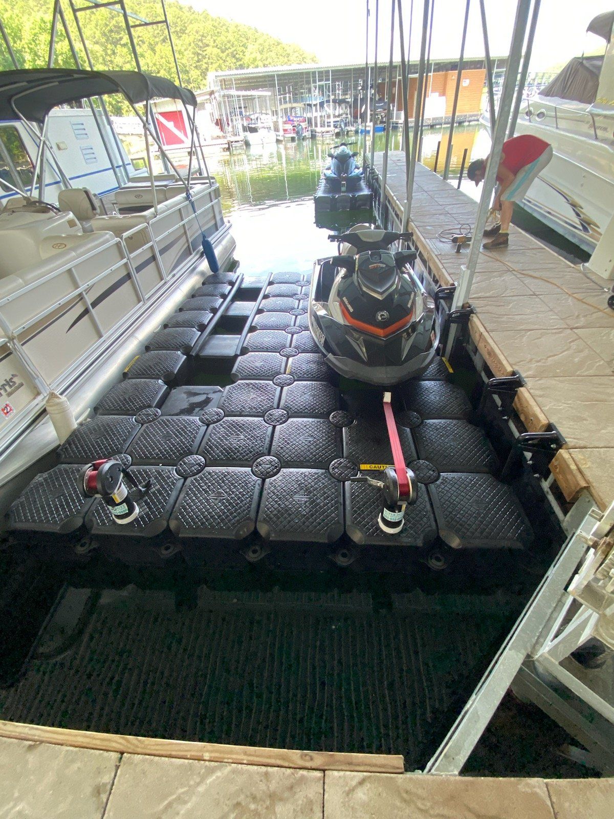 A jet ski is sitting on a dock next to a boat.