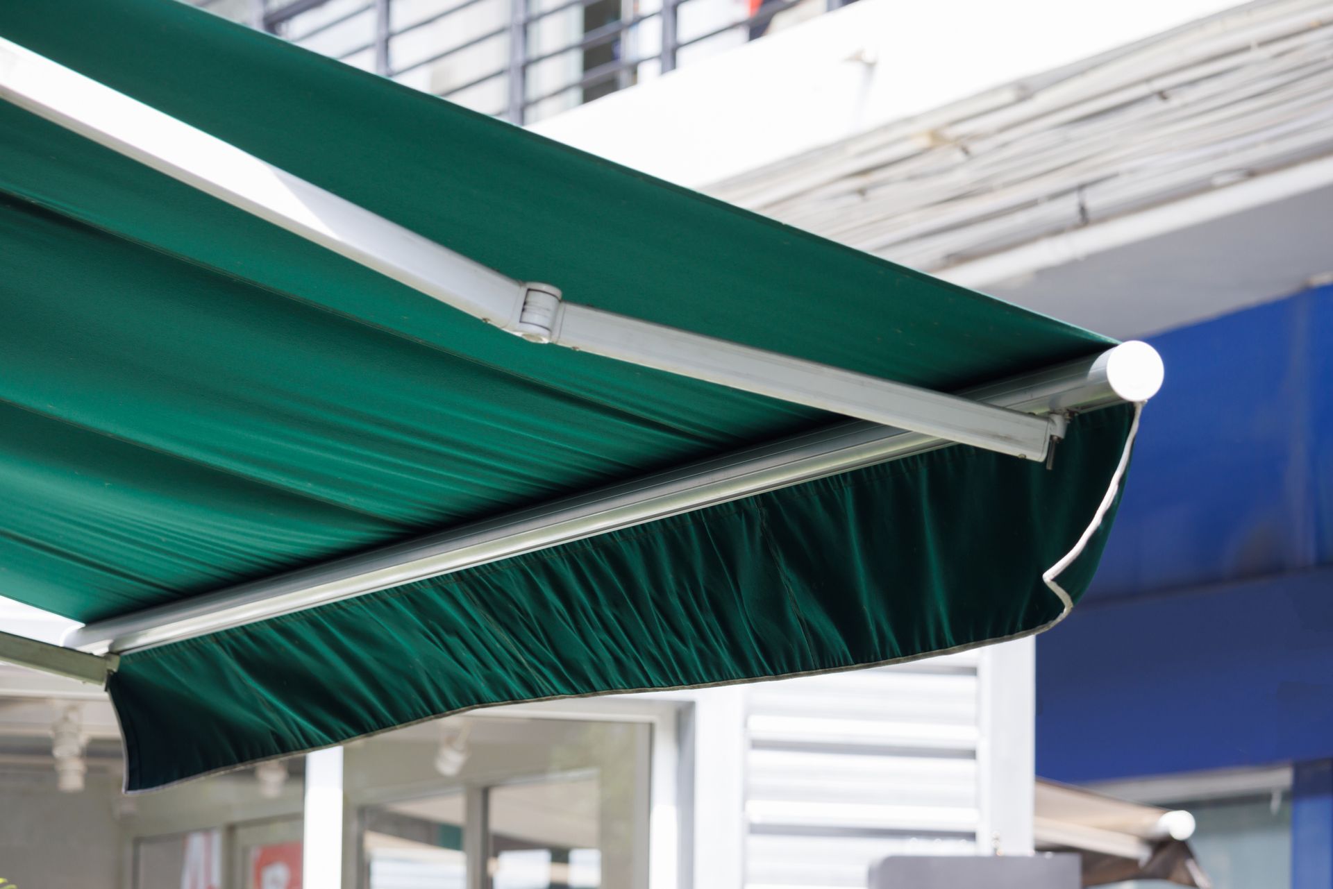 A green awning is sitting outside of a building