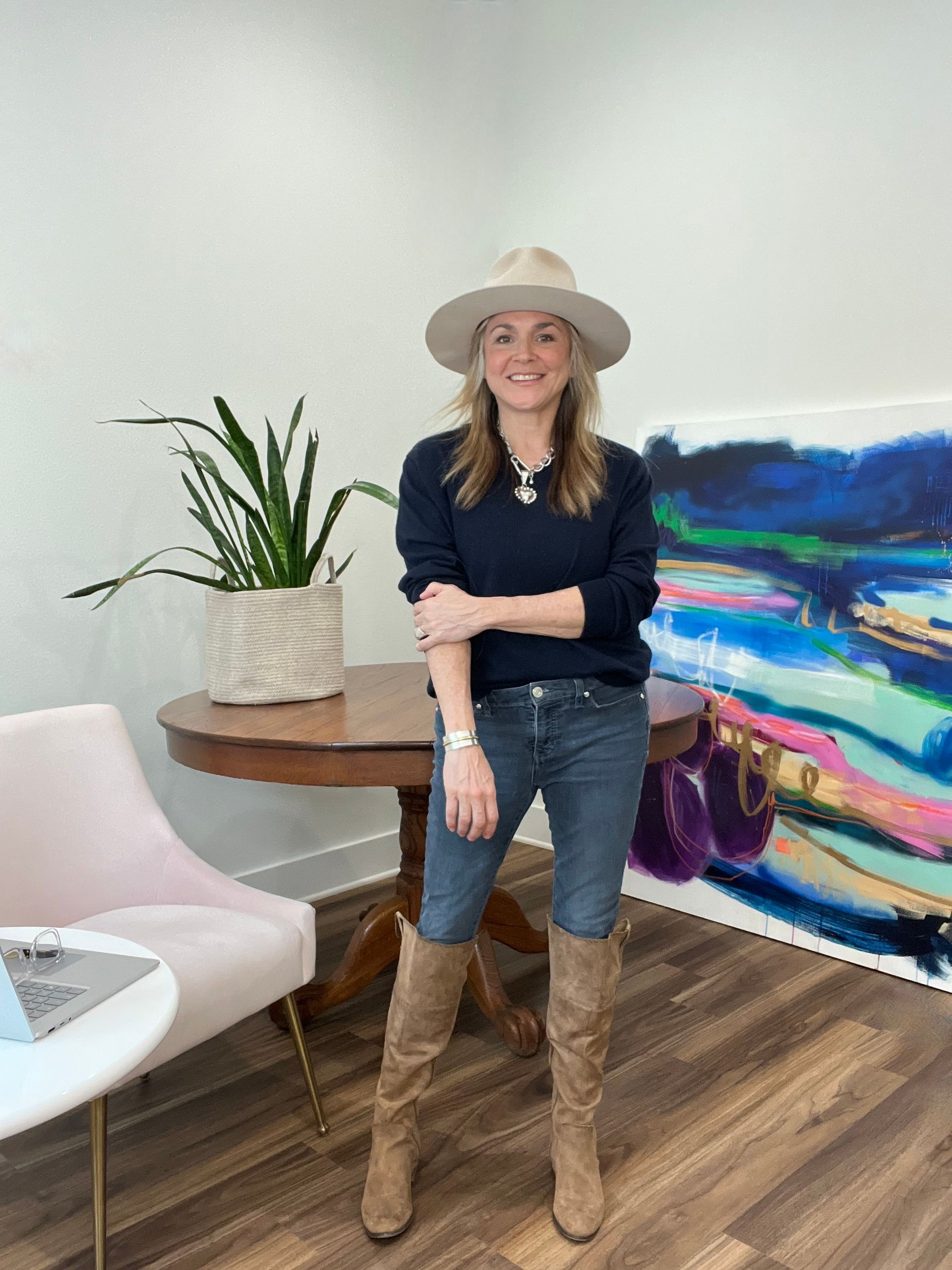 A woman in a purple scrub is posing for a picture with her arms crossed.