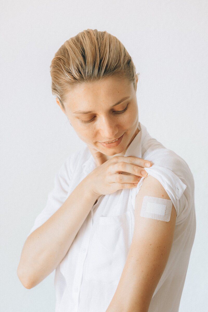 A woman is getting an injection in her arm.