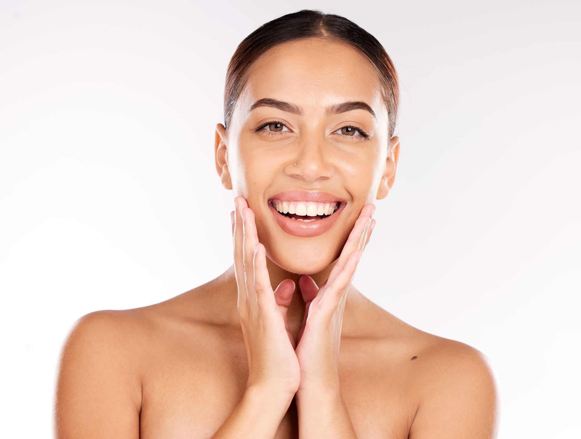 A woman is getting a facial treatment with a brush on her face.