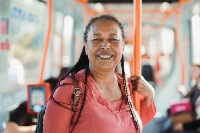 A woman with a bandage on her arm is smiling.