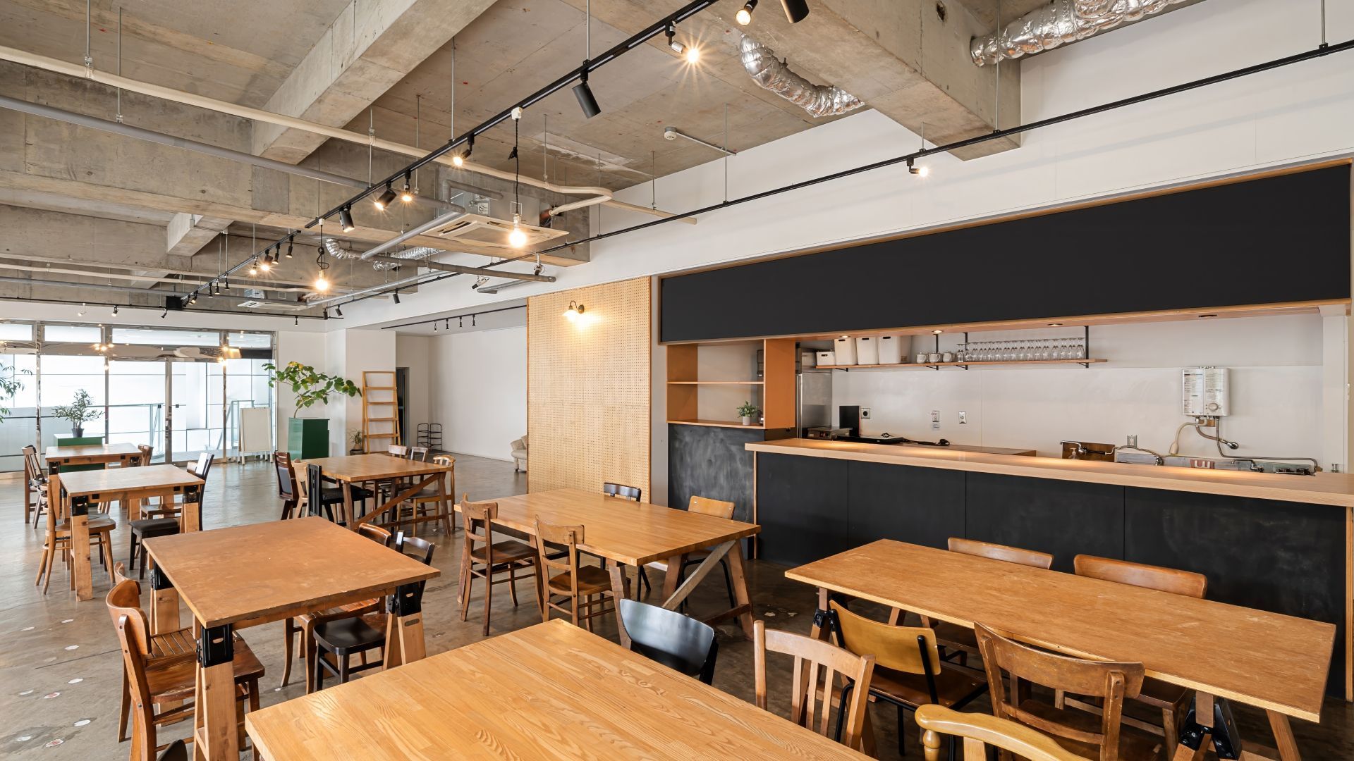 There are many tables and chairs in this large room.