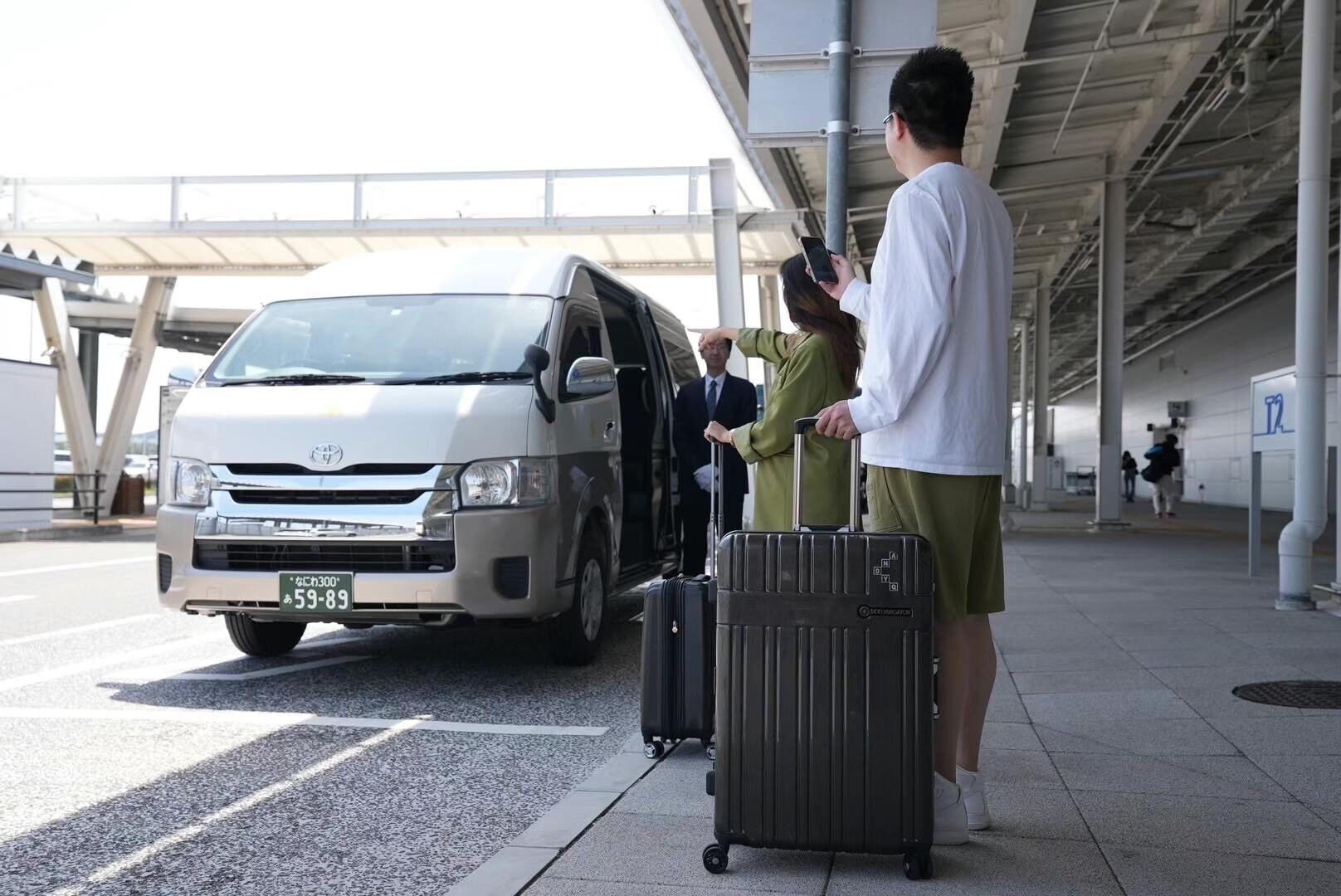 A group of people standing next to a van with luggage.