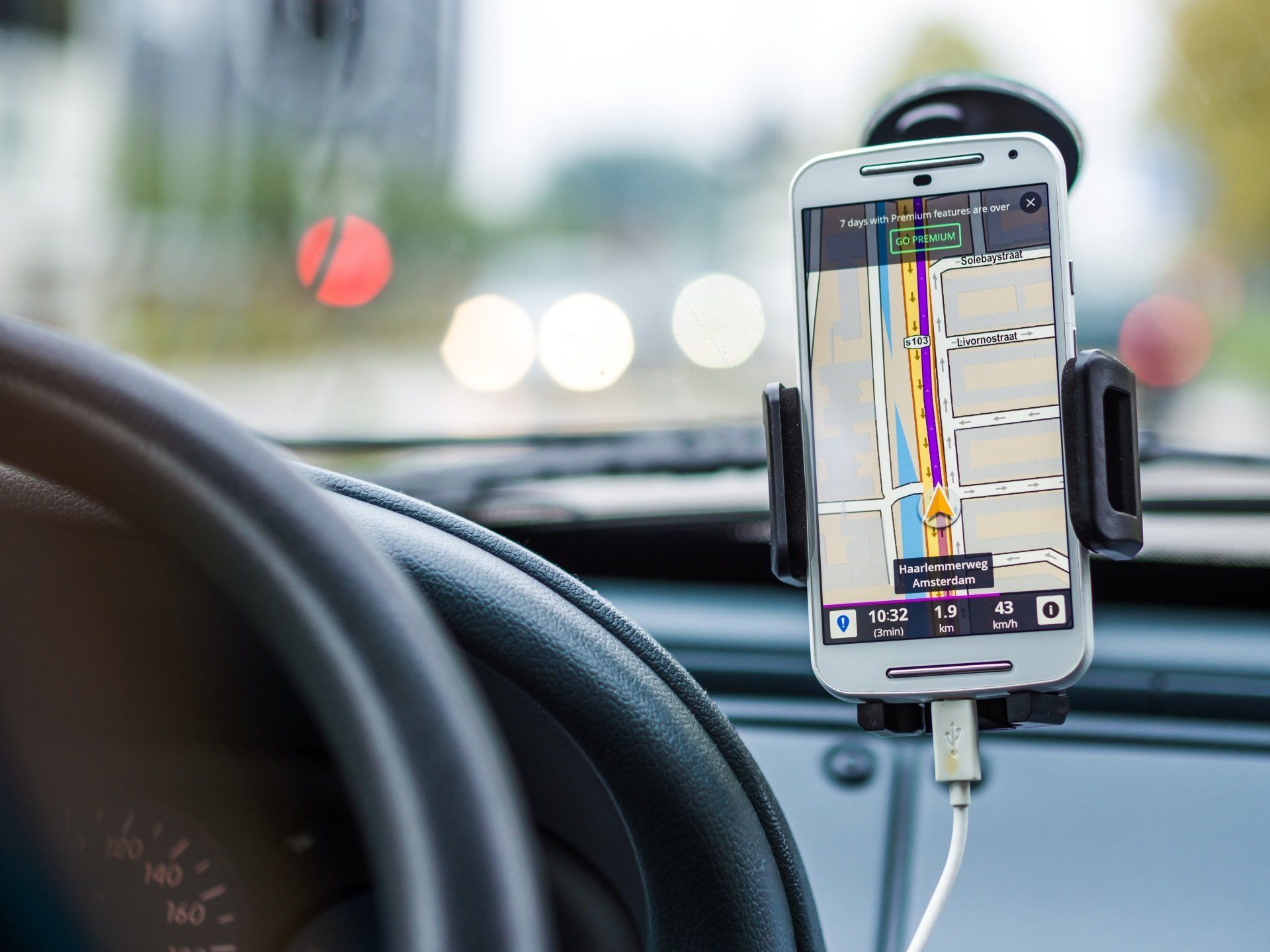 Phone mounted on a car dashboard showing a navigation map with route guidance.