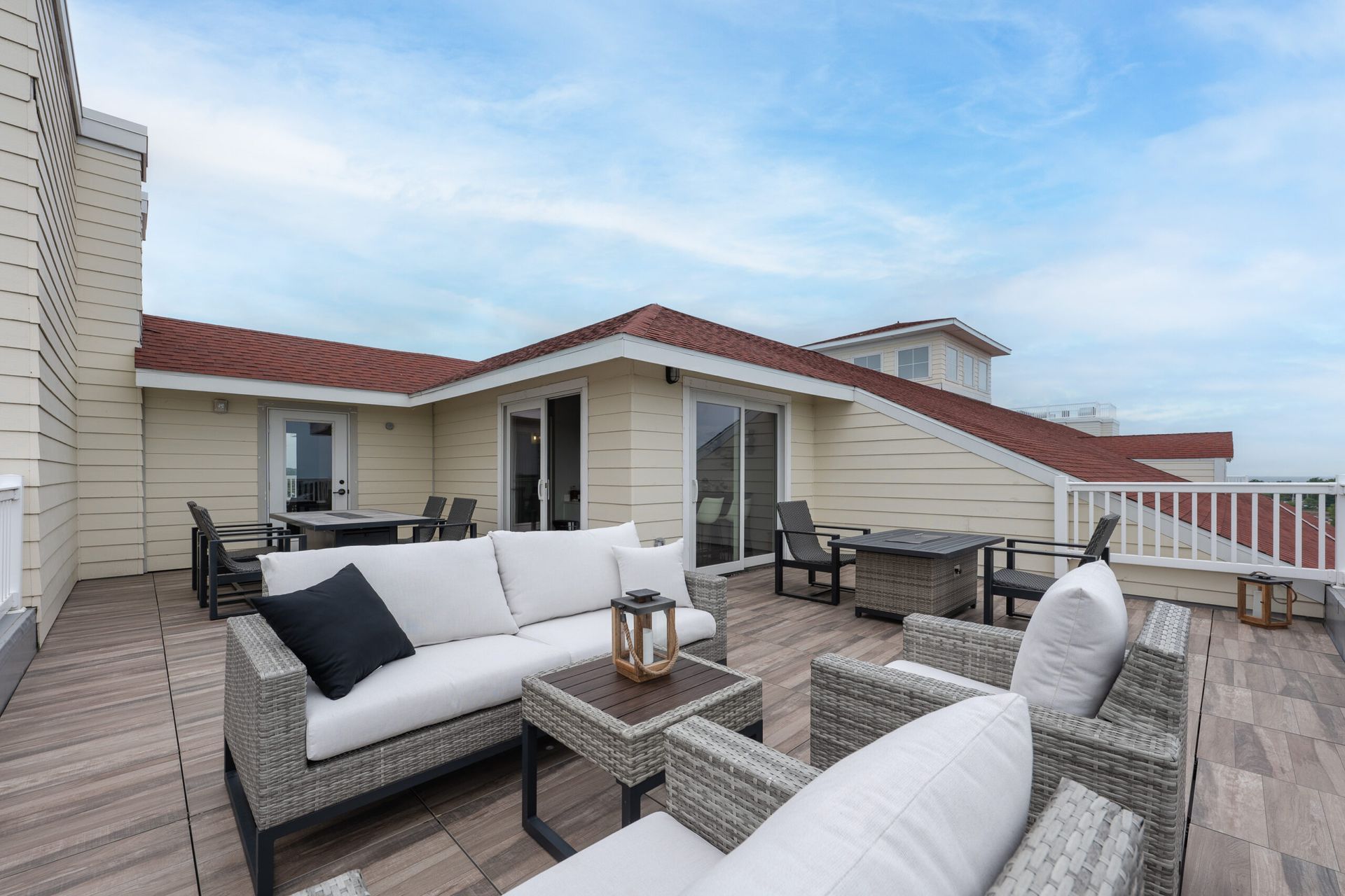 A rooftop deck with a couch and chairs on it