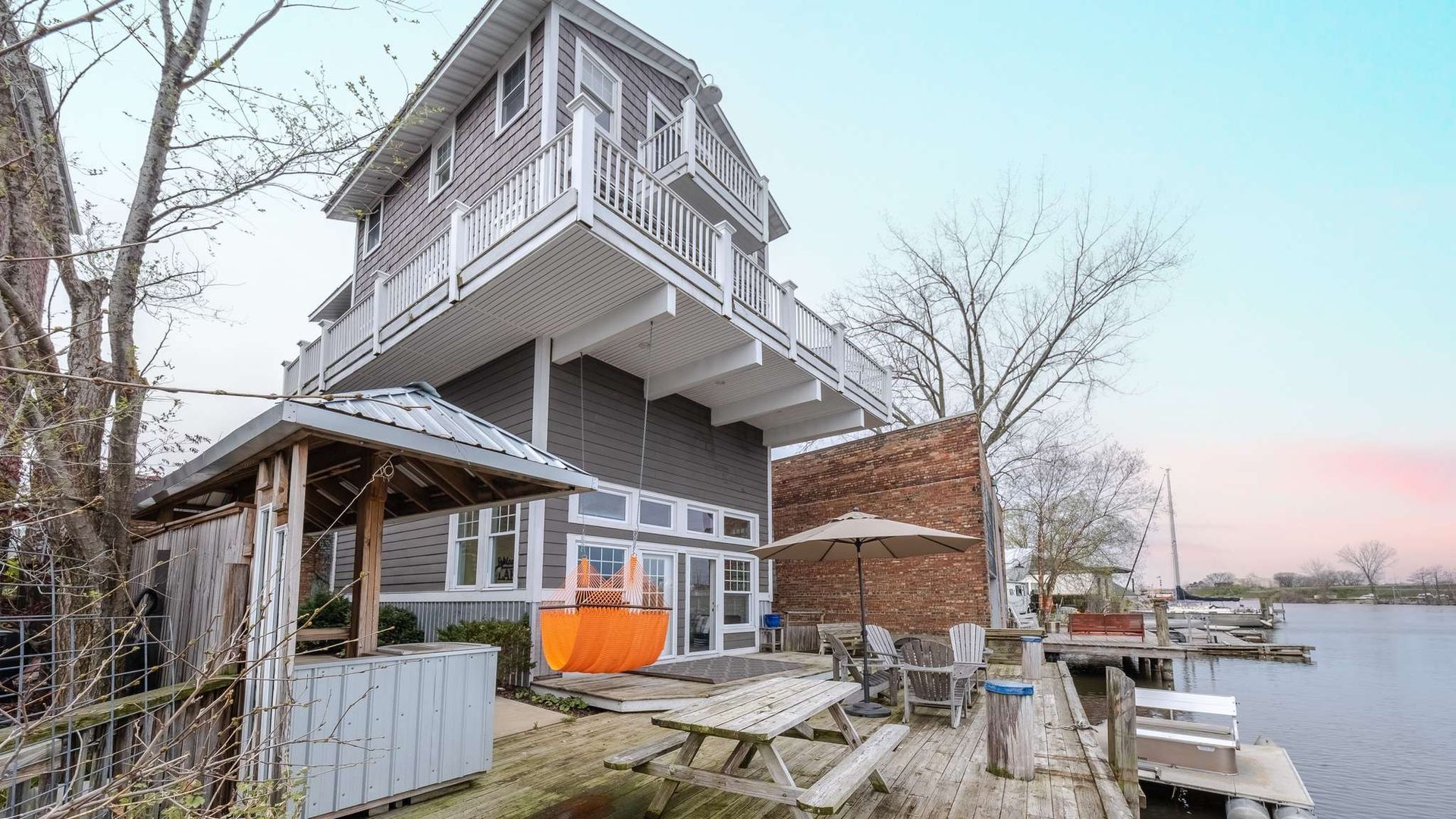 A large house is sitting on top of a small island next to a body of water.
