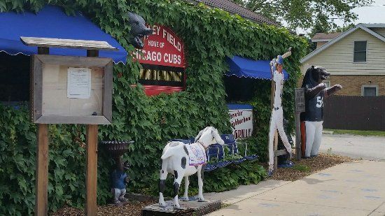 A statue of a horse is in front of a building with a sign that says chicago cubs