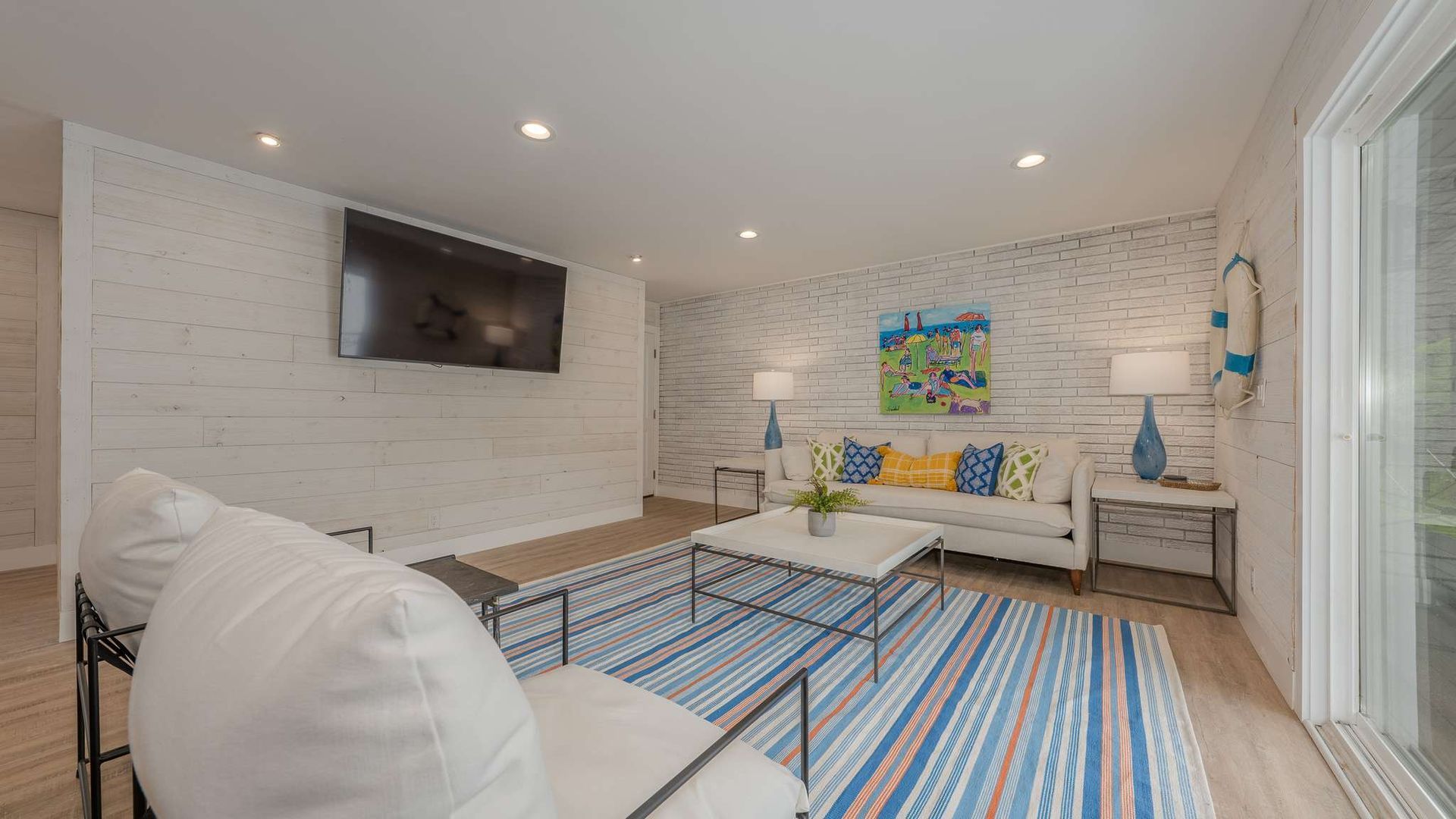 A living room with a couch , chair , coffee table and television.