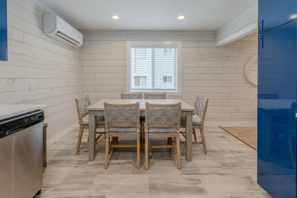 A dining room with a table and chairs and a window.