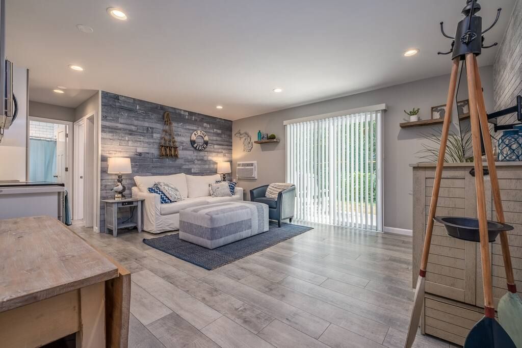 A living room with a couch , chairs , table and sliding glass doors.