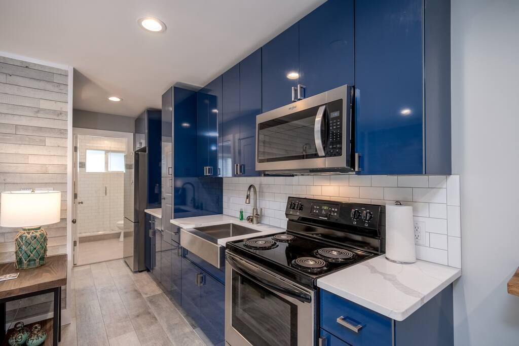 A kitchen with blue cabinets and stainless steel appliances.