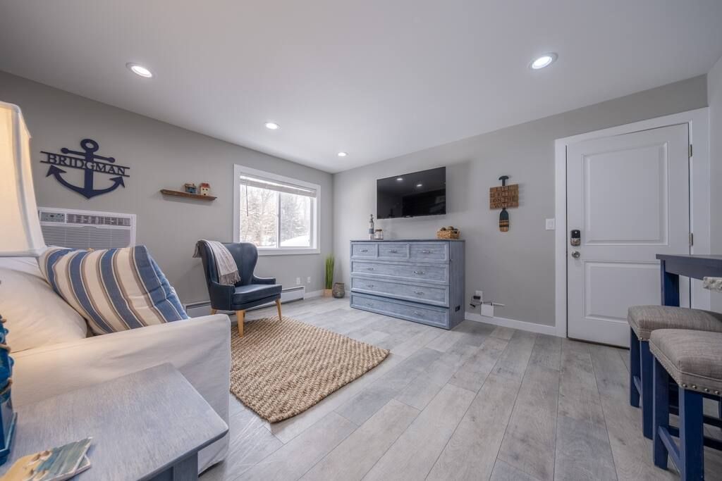 A living room with a couch , chair , table and television.