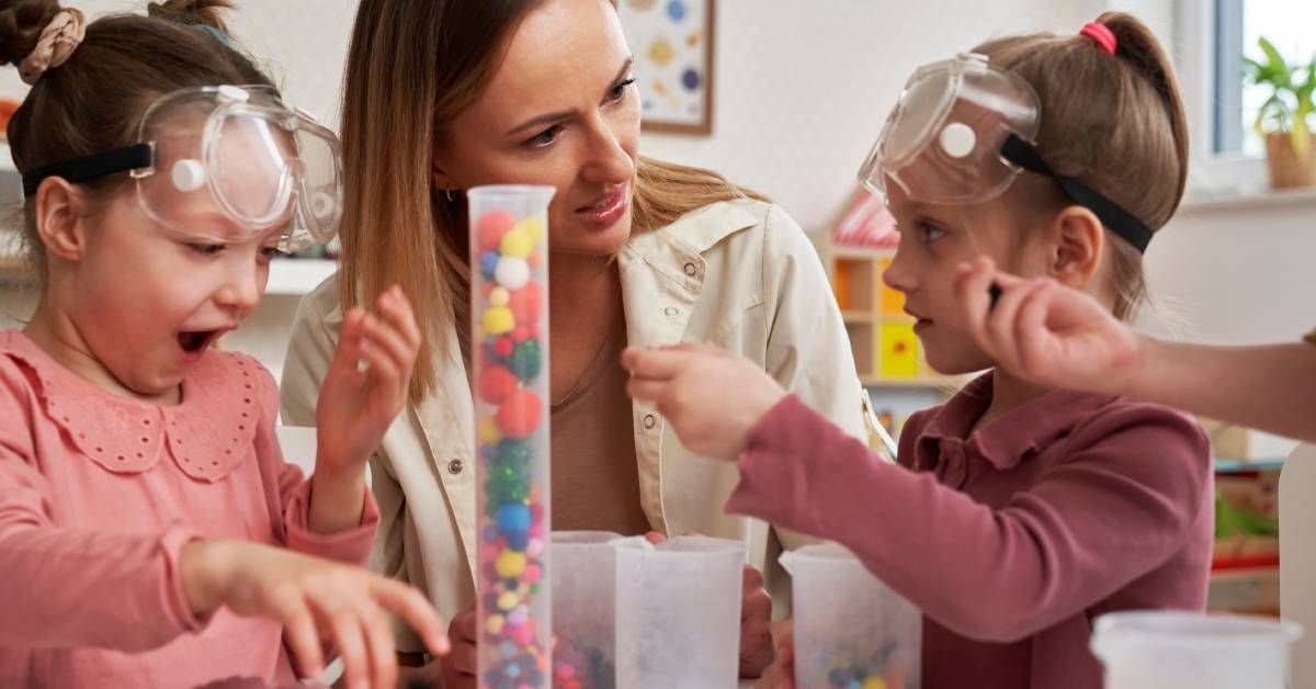 Children in lab glasses are having sensory exercises while the female instructor looks at one of the girls inquisitively. 