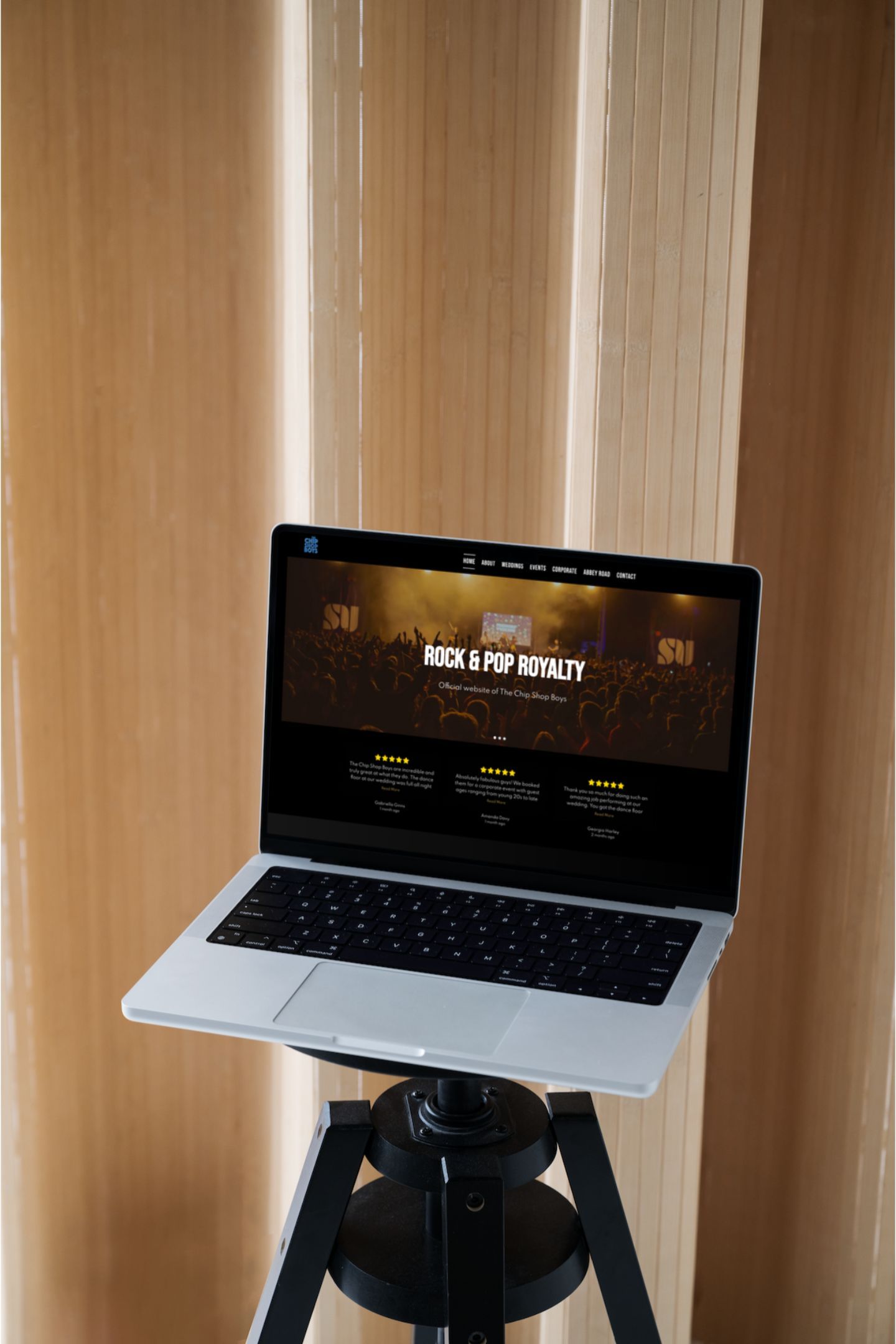 A laptop is sitting on a tripod in front of a window.