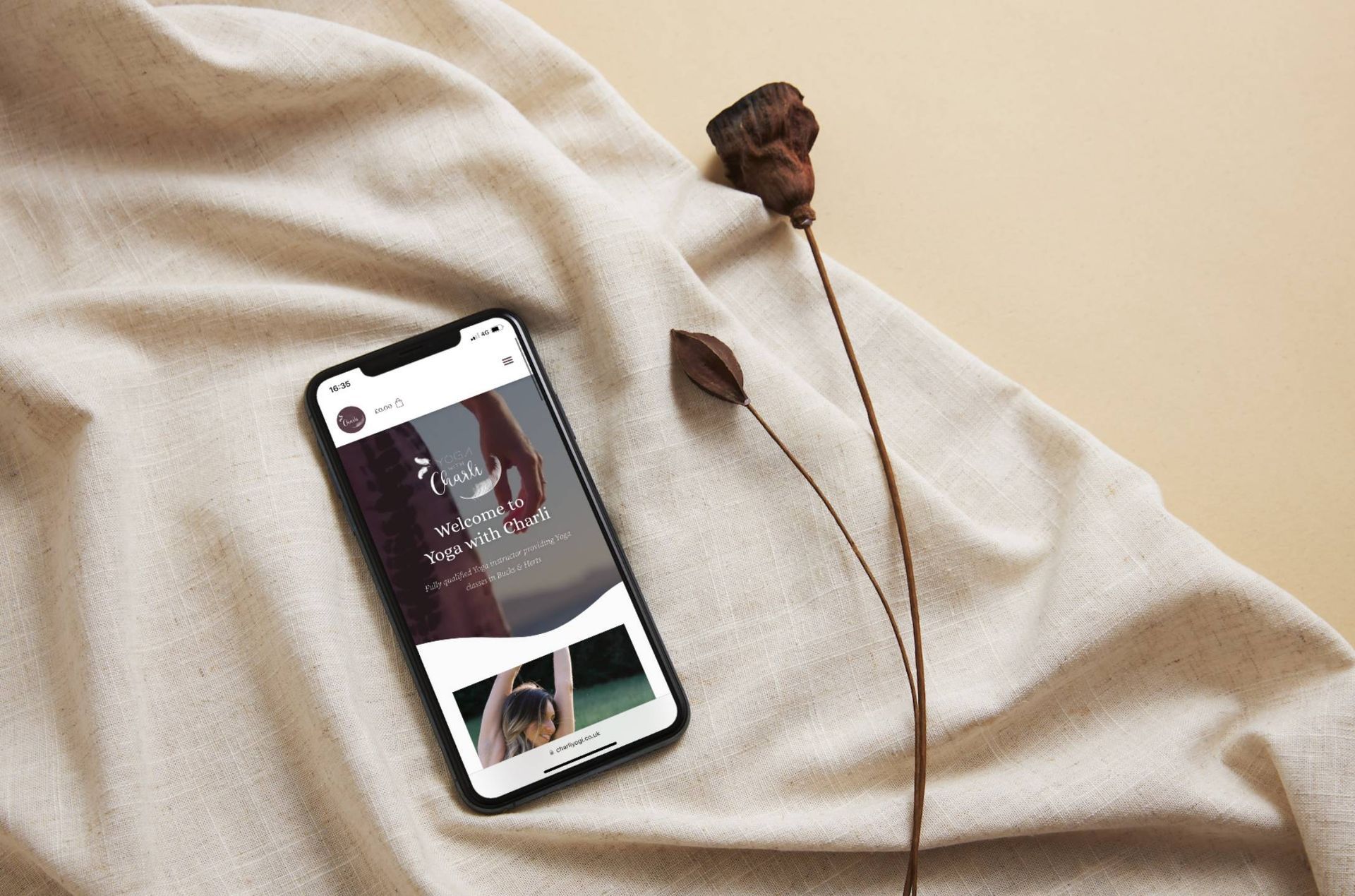 A cell phone is sitting on a piece of cloth next to a flower.