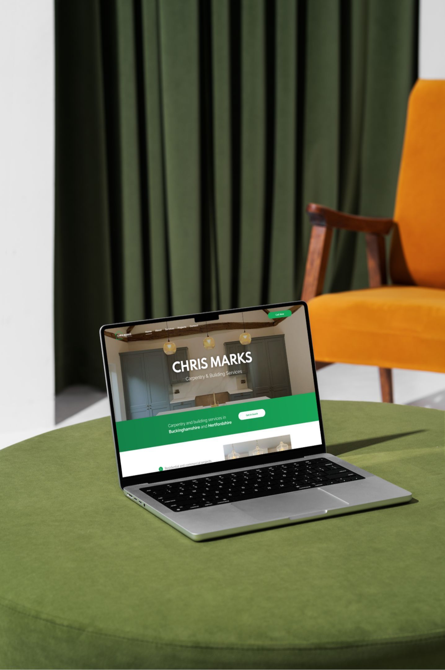 A laptop is sitting on a table next to a chair.