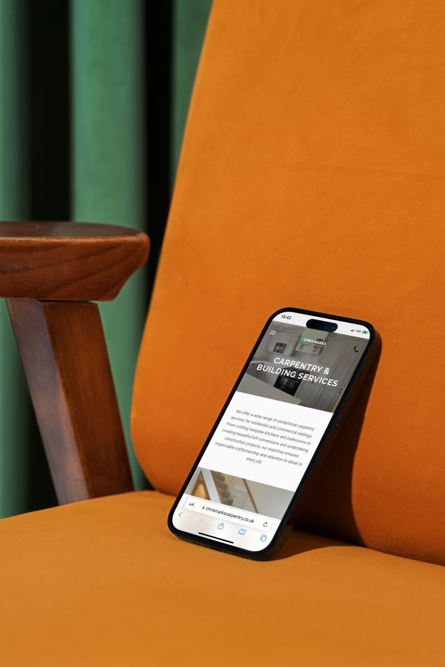 A cell phone is sitting on top of an orange chair.