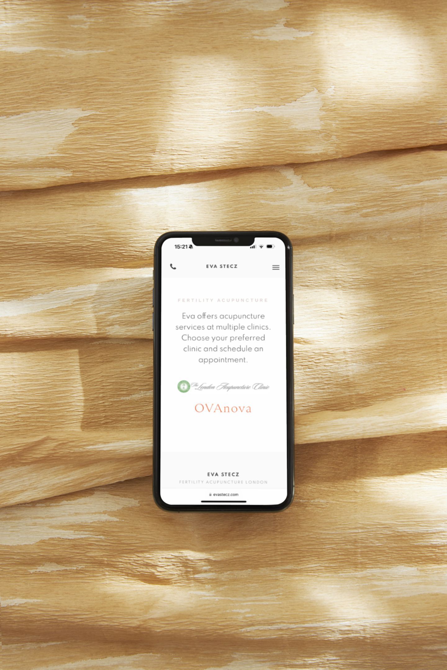 A cell phone is sitting on a wooden table.