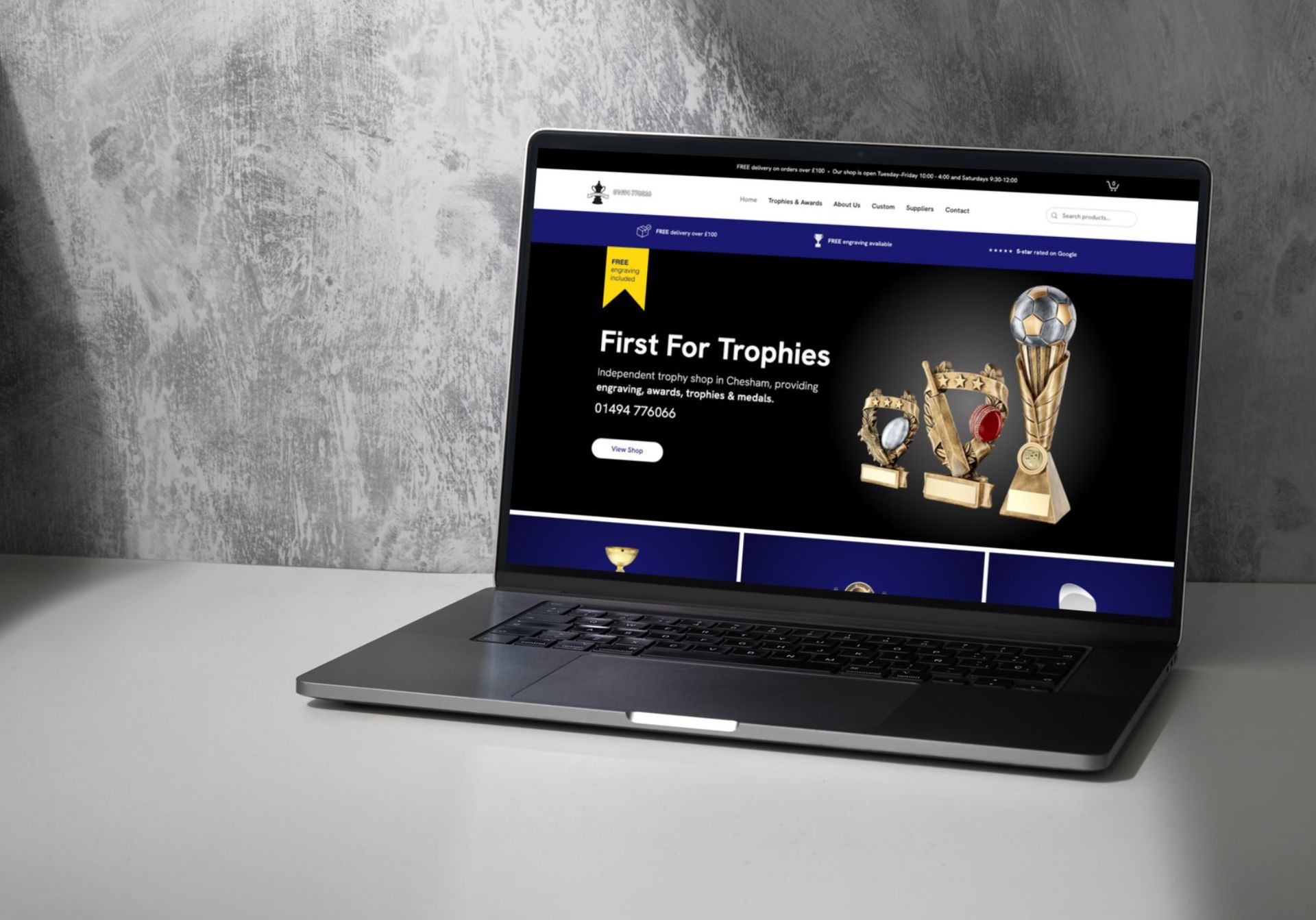 A laptop is open to a website that says first for trophies