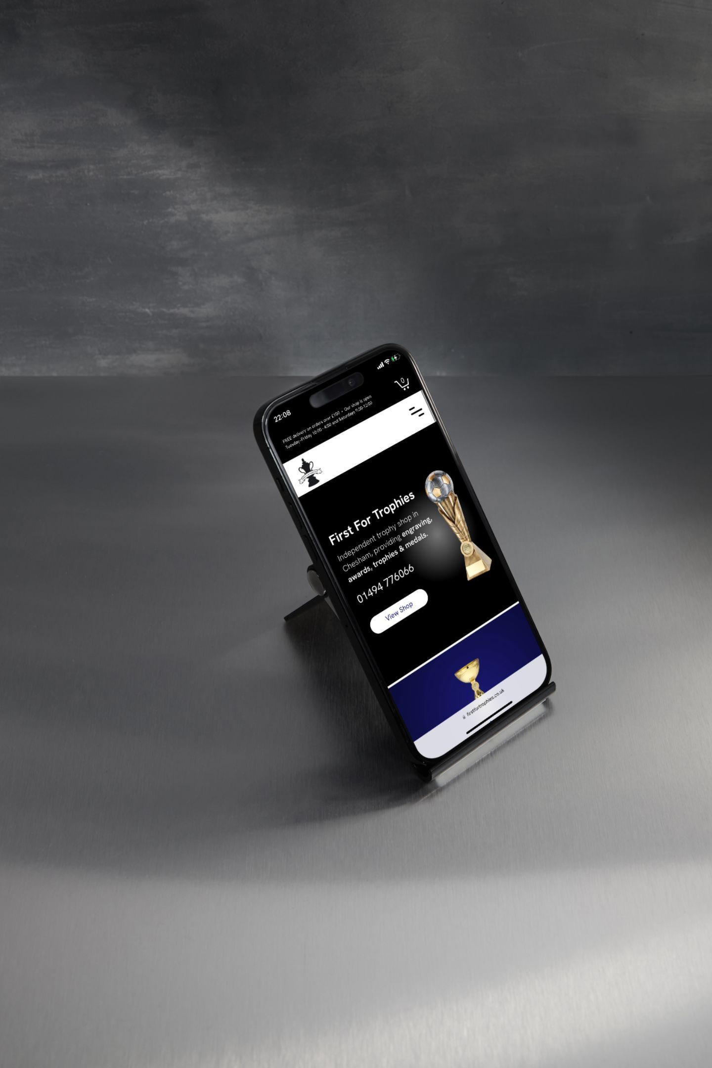 A cell phone is sitting on a table with a trophy on the screen.