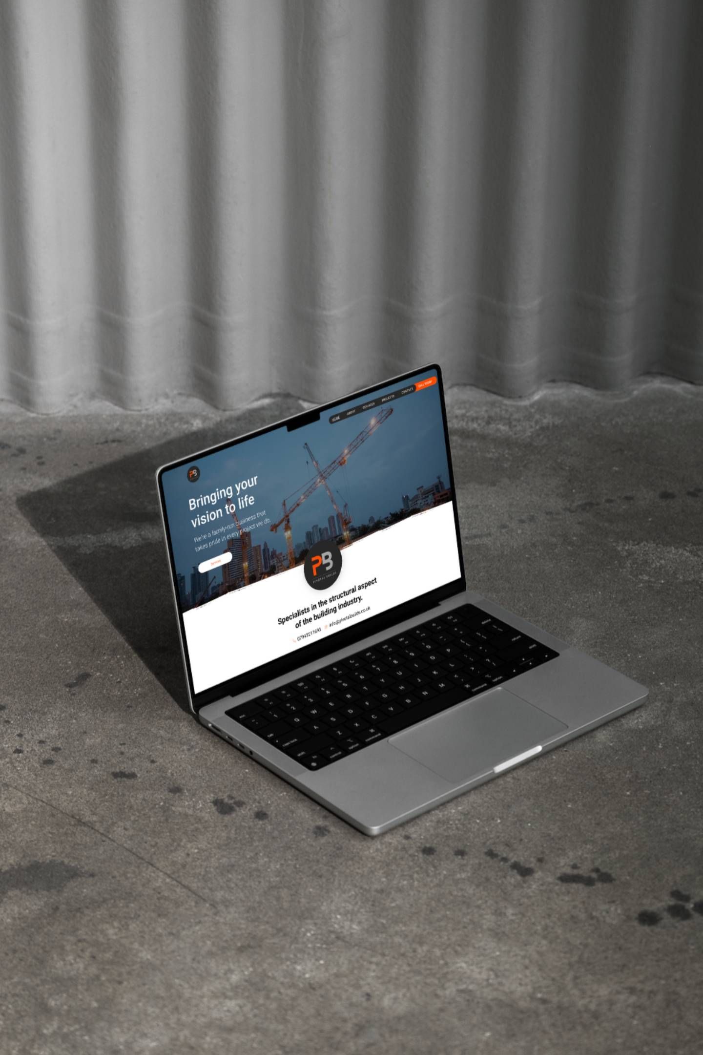 A laptop computer is sitting on a concrete floor.