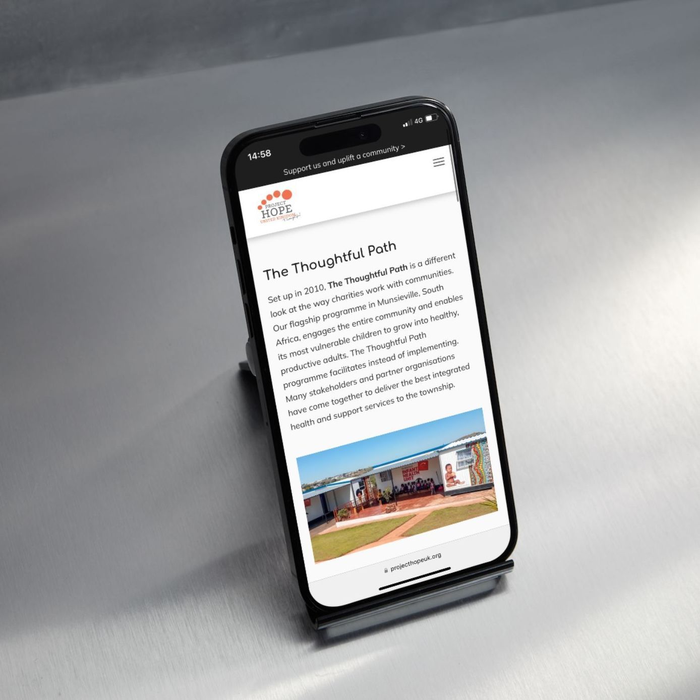 A laptop computer is open to a video of a woman sitting on a stool.