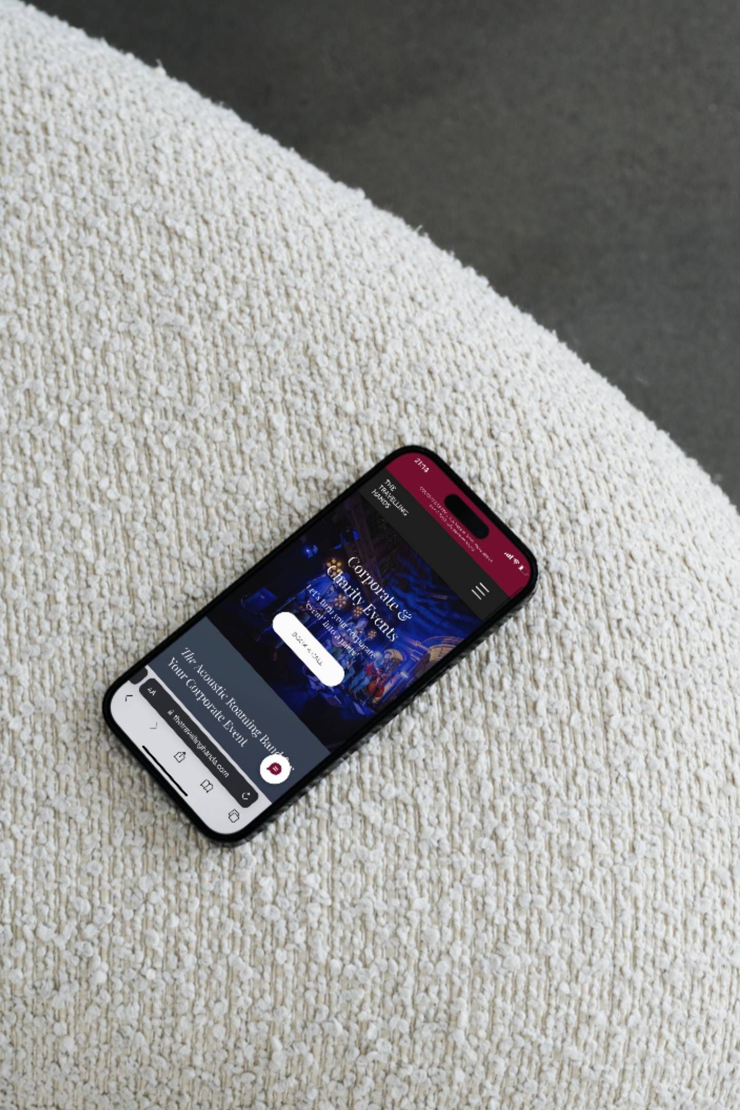 A cell phone is sitting on top of a white cushion.