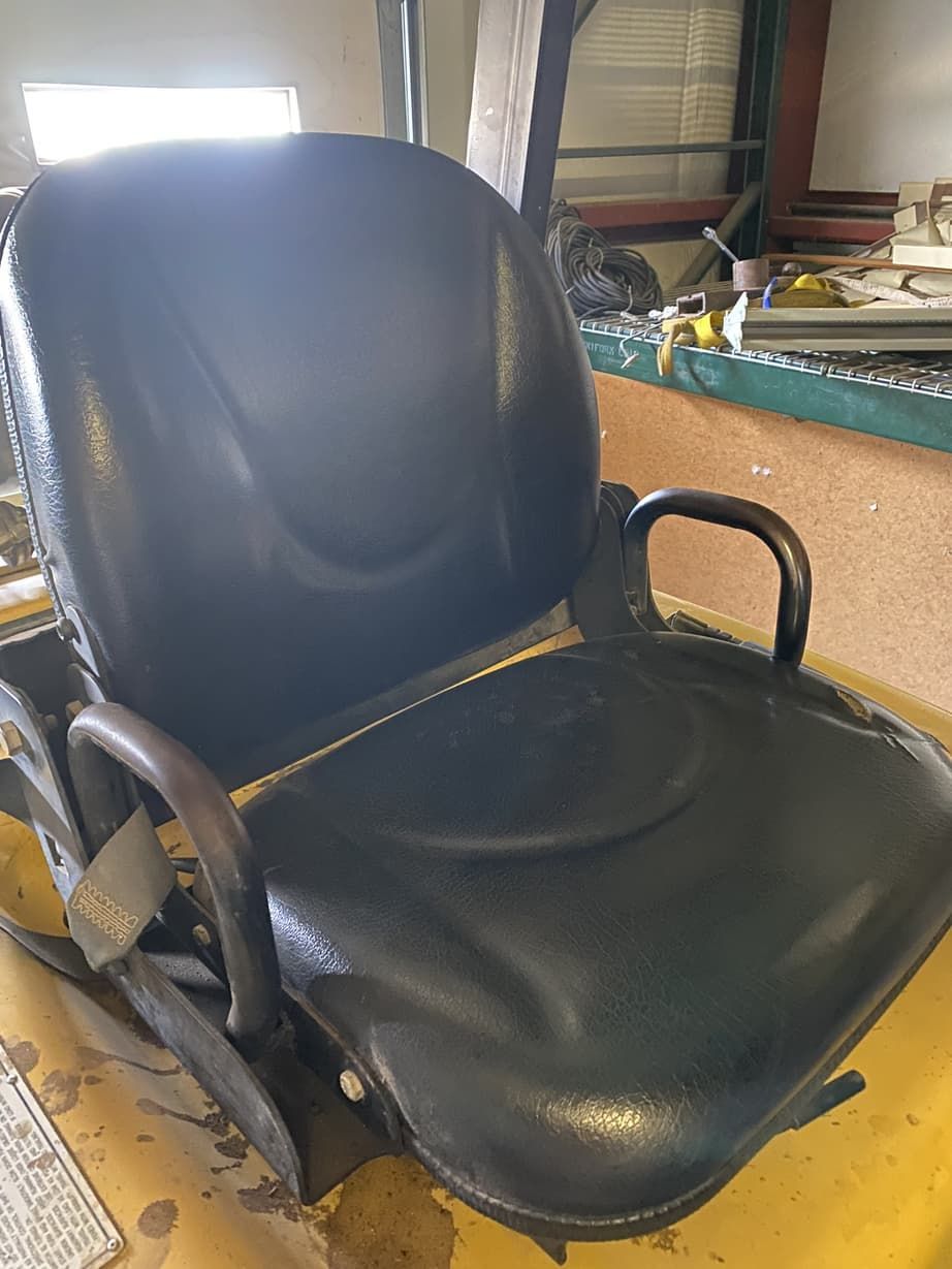 A black office chair is sitting on top of a yellow table.