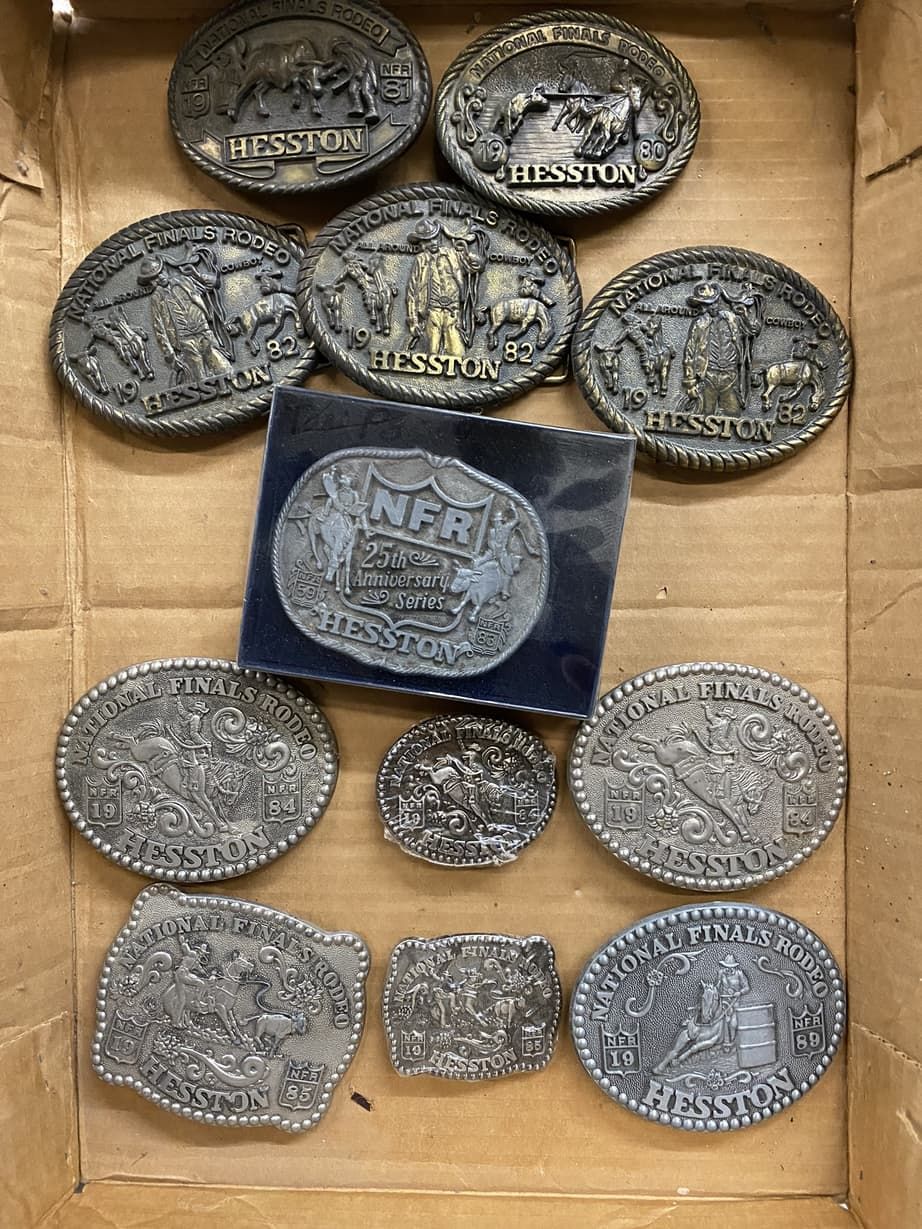 A box filled with a variety of belt buckles